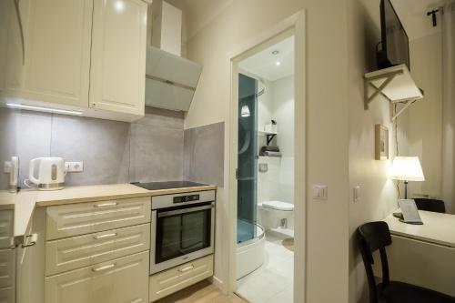 una cucina con mobili bianchi, un lavello e una stufa di Renovated apartment in Riga center a Riga