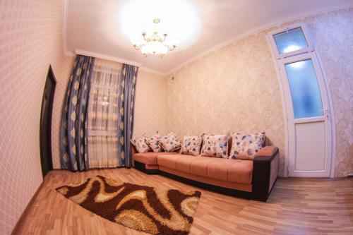 een woonkamer met een bank en een raam bij "METROPOL" APARTMENT HOTEL in Baku