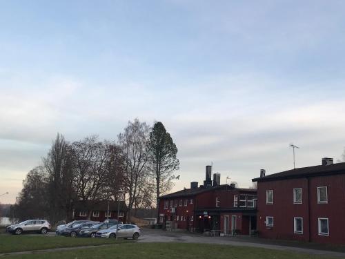 a group of cars parked in a parking lot next to buildings at Klackbergsgården in Norberg