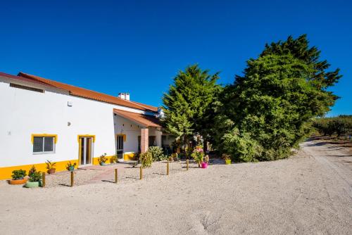 a building with trees and potted plants in front of it at Vale do Grou Natura in Óbidos