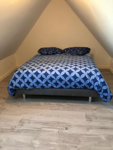 - un lit avec une couette bleue dans l'établissement Duplex Hyper centre colmar, à Colmar