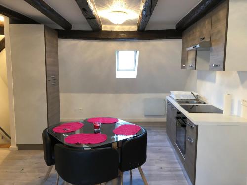 - une cuisine avec une table noire et des serviettes rouges dans l'établissement Duplex Hyper centre colmar, à Colmar
