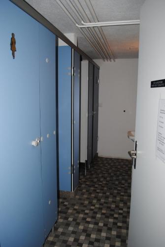 a hallway with blue doors and a checkered floor at Hotel Des Alpes in Kandersteg