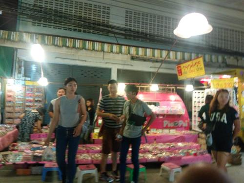 a group of people standing in a market at T&P at Pai in Pai