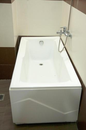 a white bath tub with a sink in a bathroom at Hoang Thuy Sinh Hotel in Da Nang