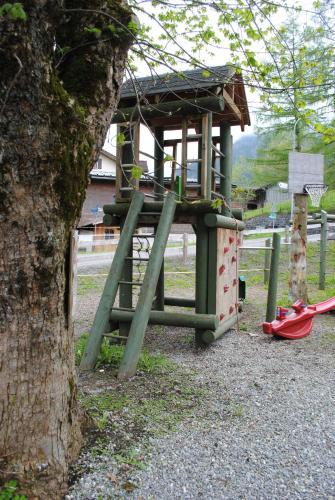 a park with a playground with a tree at Hotel Des Alpes in Kandersteg