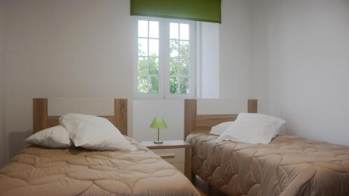 two beds in a room with a window at BELO CAMPO - Ilha do Faial (Horta) in Castelo Branco