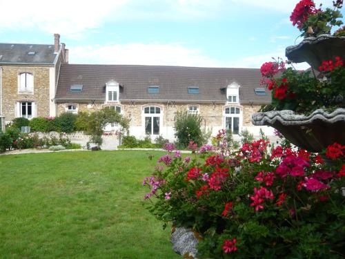 a large brick house with flowers in a yard at Domaine d'Auxonnettes Chambres d'Hôtes et Gîtes in Saint-Fargeau-Ponthierry