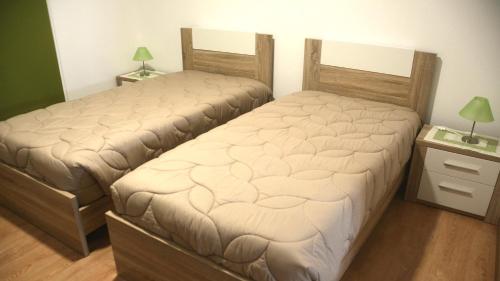 two twin beds in a room with two lamps at BELO CAMPO - Ilha do Faial (Horta) in Castelo Branco