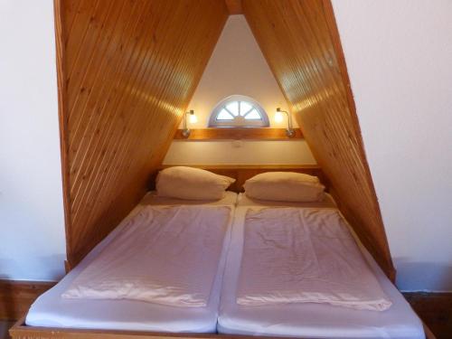2 Betten in einem kleinen Zimmer mit Fenster in der Unterkunft Ferienwohnung Anne in Nebel