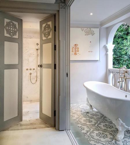 a bathroom with a tub and a walk in shower at The Inside House in Chiang Mai