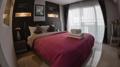 a bedroom with a large bed with a red blanket at Step One at Bangkok in Bangkok