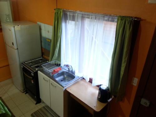 a small kitchen with a sink and a window at Departamento a minutos del centro in Puerto Montt