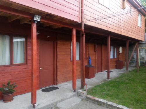a building with red columns and a red door at Departamento a minutos del centro in Puerto Montt