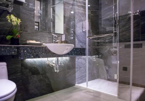 a bathroom with a sink and a glass shower at NingXiaYah Stay in Taipei