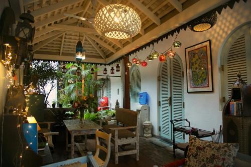 a living room with a table and chairs and a chandelier at LE JARDIN DU FORT - GALLE in Galle