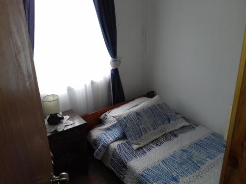 a small room with a bed and a window at Departamento a minutos del centro in Puerto Montt