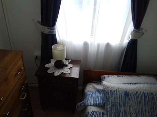 a bedroom with a bed and a candle on a table at Departamento a minutos del centro in Puerto Montt
