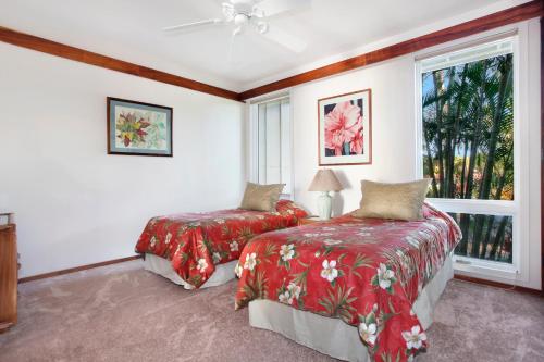 a bedroom with two beds and a window at Whalers Cove in Poipu in Koloa