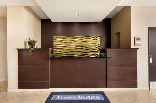 a lobby with a yellow and black painting on the wall at Travelodge Hotel by Wyndham Weyburn in Weyburn