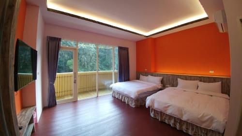 two beds in a room with orange walls at Grandma Yu's B&B in Yuchi