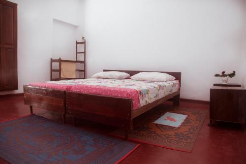Un dormitorio con una cama con marco de madera. en Aeroform Homestay, en Negombo
