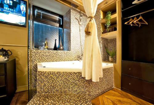 uma casa de banho com uma banheira e uma janela em Montefiore 16 - Urban Boutique Hotel em Tel Aviv
