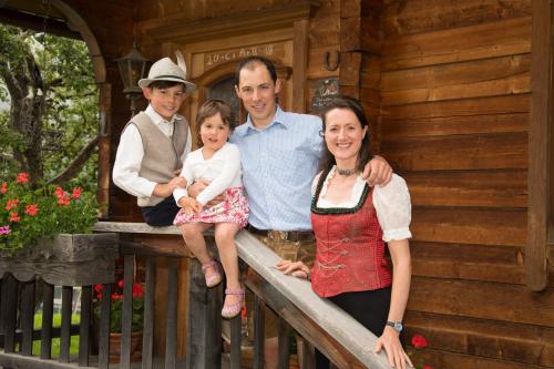 a family posing for a picture in front of a cabin at BIO-Bergbauernhof Ederhias in Liesing