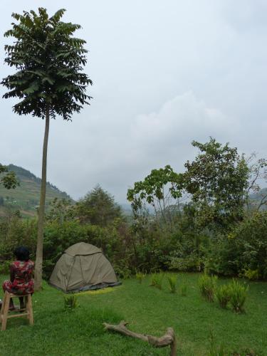 a person sitting in a chair next to a tent at Karungi Camp in Rubuguli