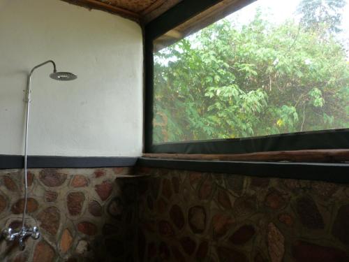 a shower in a room with a window at Karungi Camp in Rubuguli