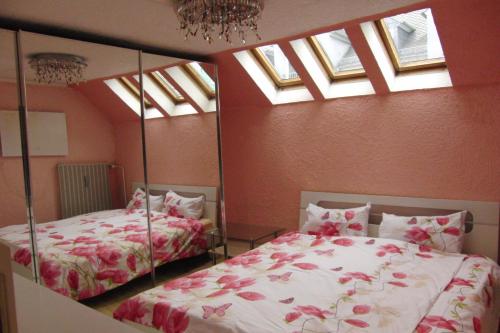 2 Betten in einem Schlafzimmer mit Oberlichtern und Fenstern in der Unterkunft Ferienwohnung Volskyy in Trier