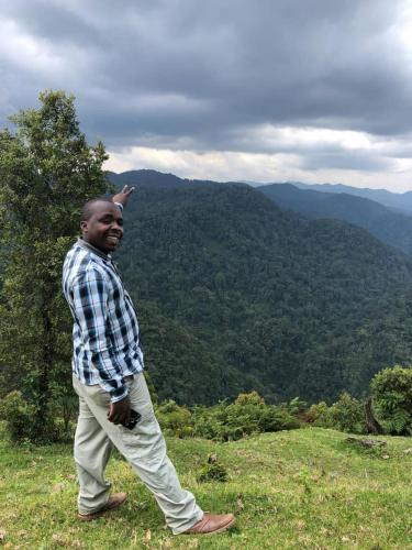 a man walking on a hill with his arm in the air at Karungi Camp in Rubuguli