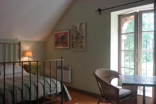 1 dormitorio con cama, mesa y ventana en le Petit Paris, en Flagey-Échézeaux