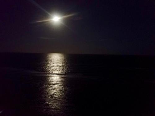 a full moon over the ocean at night at Paraiso dos Corais in Guarajuba