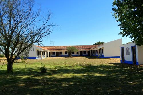 a building with a tree in the middle of a field at Monte do Paco in Montemor-o-Novo