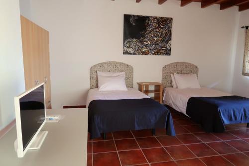 モンテモル・オ・ノボにあるMonte do Pacoのベッド2台とテレビが備わる客室です。