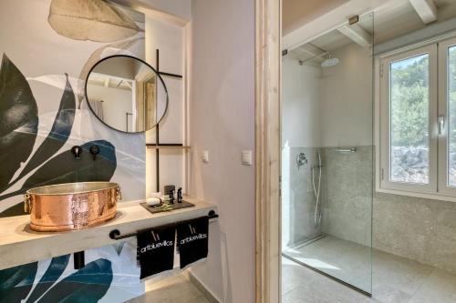 a bathroom with a sink and a shower at Artblue Villas in Tsoukaladhes