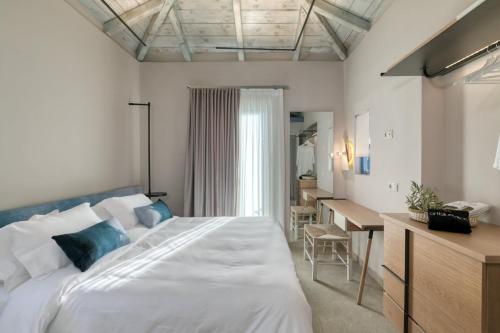 a bedroom with a large bed and a desk at Artblue Villas in Tsoukaladhes