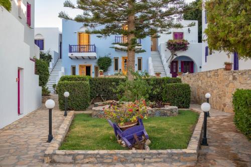a garden with a blue bench in front of a house at Nefeli Hotel Leros in Agia Marina