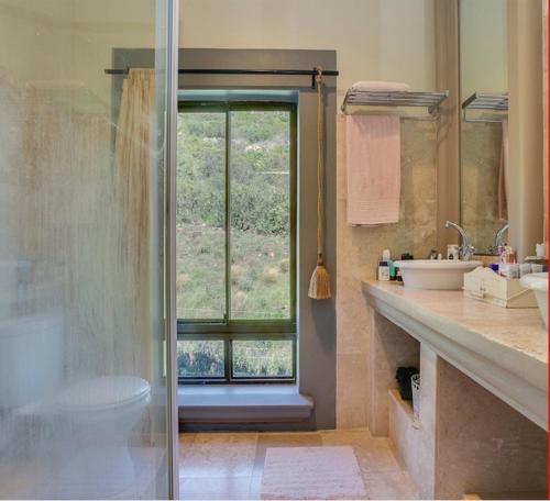 a bathroom with a shower and a toilet and a window at Casa a Capri, Capri Village, Cape Town in Fish hoek