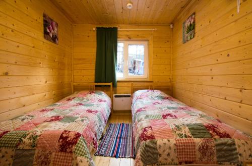 1 dormitorio con 2 camas en una cabaña de madera en Annilahti en Lumivaara