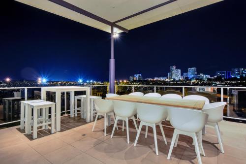 a table and chairs on a balcony at night at Luxury Darwin City Lights Jacuzzi Central Location Large House New Furnishings in Darwin