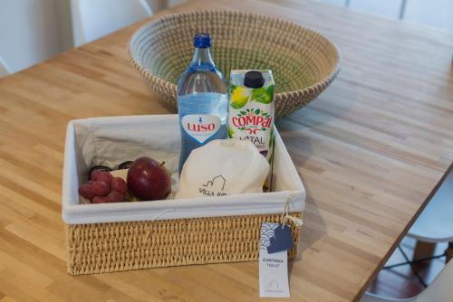 a lunch box with a bottle and fruit on a table at Villa Eira in Vila Nova de Milfontes