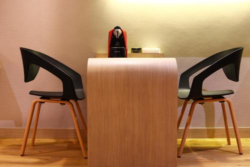 two chairs sitting next to a table with a purse on top at Montana Hotel Songkhla in Songkhla