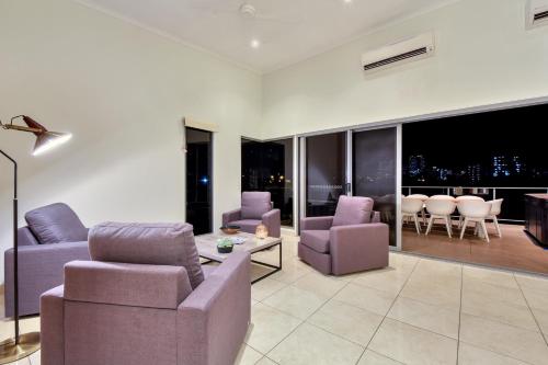 a living room with purple furniture and a view of the city at Luxury Darwin City Lights Jacuzzi Central Location Large House New Furnishings in Darwin
