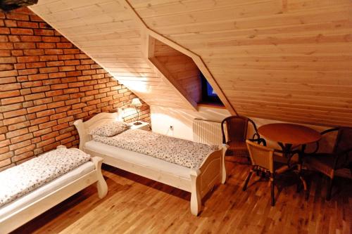 Habitación en el ático con 2 camas y mesa en Dworek Pod Wiechą, en Kawęczyn