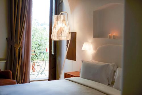 a bedroom with a bed and a lamp and a window at Aquamarea in Polignano a Mare