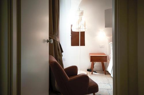 a living room with a chair and a table at Aquamarea in Polignano a Mare