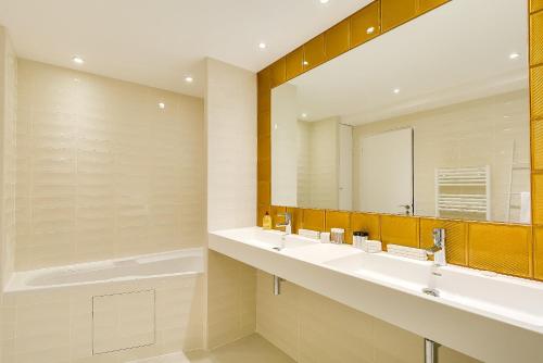 une salle de bain avec deux lavabos et un grand miroir dans l'établissement LE VAUGIRARD - 3bedrooms Apartment Premium, à Paris
