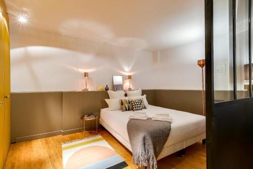 een slaapkamer met een bed met witte lakens en kussens bij LE VAUGIRARD - 3bedrooms Apartment Premium in Parijs